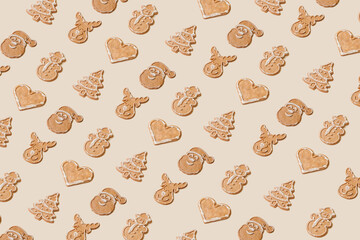 Creative pattern with different brown gingerbread cookies on pastel cream background. Winter sweets wallpaper.
