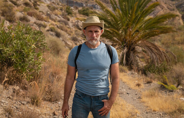 Portrait of adult man in cowboy hat in oasis of desert area. Shot in Almeria, Spain