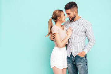 Sexy smiling beautiful woman and her handsome boyfriend. Happy cheerful family having tender moments near blue wall in studio.Pure cheerful models hugging.Embracing each other