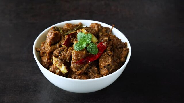 Traditional homemade Mutton curry from Asian cuisine. Chukhandar gosht. Spicy delicious meat beef curry 4K video footage mutton roast Indian spices. side dish of Ghee rice, Appam, Parotta, Puttu