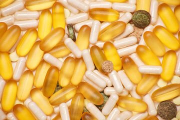 Mix of pharmaceutical medicine white, yellow and natural organic green tablet capsule pills medicine full frame background