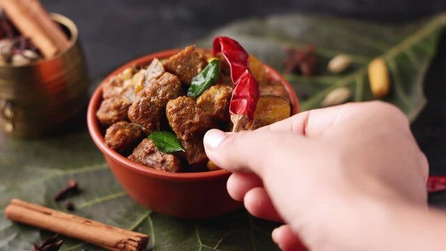 Traditional homemade Mutton curry from Asian cuisine. Chukhandar gosht  woman hand serving spicy meat beef curry 4K video footage mutton roast Indian spices. side dish Ghee rice Appam Parotta Puttu