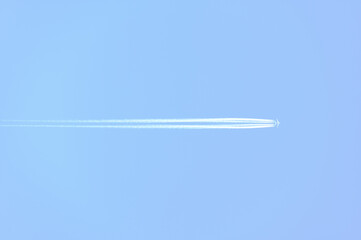 Traces and white streaks from the jet engines in the plane, white stripes in the sky.