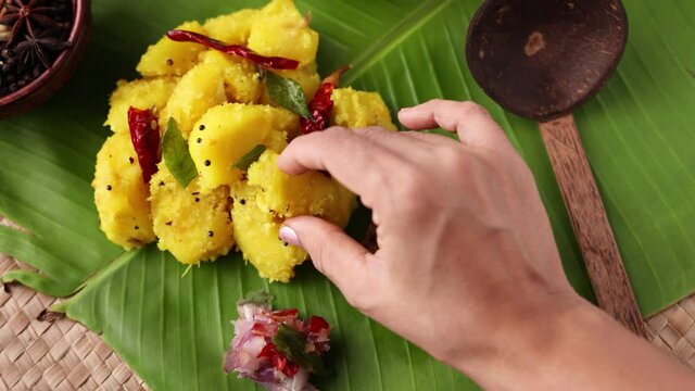 Cooked tapioca Cassava root Kappa with spicy meat beef pork curry Mandioca Aipim Indian food woman eating with hand banana leaf 4K video footage South Indian food Asian cuisine Kerala India Sri Lanka
