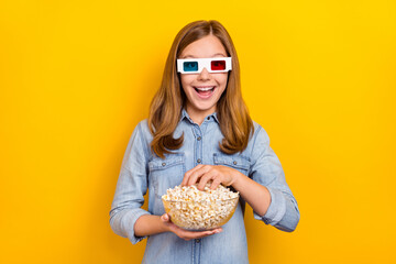 Photo of funky small blond girl eat pop corn wear eyewear denim shirt isolated on bright yellow color background