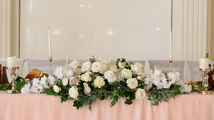 Decorated wedding hall, served tables and dishes, round tables and a bright hall.