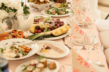 Decorated wedding hall, served tables and dishes, round tables and a bright hall.