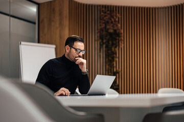 Adult caucasian man with glasses, checking the company security system.