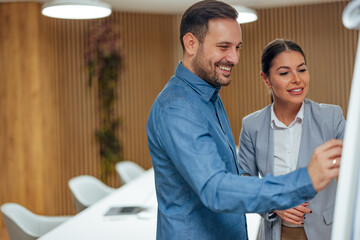 Obraz premium Joyful business partner, trying out the new whiteboard their office got.
