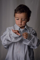 portrait of little boy wearing a big shirt from his father