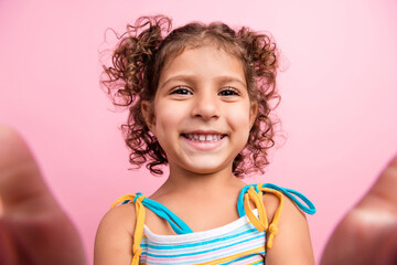 Self-portrait of attractive cheerful wavy-haired girl having fun good mood isolated over pink pastel color background