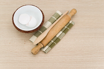 natural solid wood kitchen tools and table napkin with eggs on a wooden tabletop