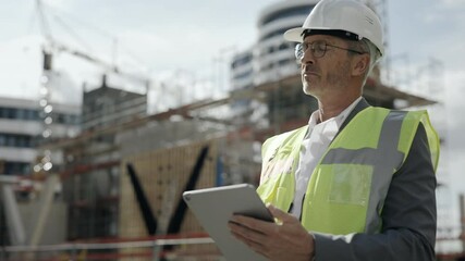 Architect standing on construction site and using tablet