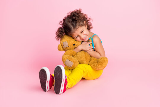 Portrait of attractive funny cheerful wavy-haired girl hugging bear spending time isolated over pink pastel color background