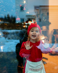 child in santa hat with christmas presents