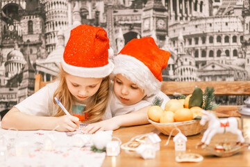 very beautiful children in a cute Santa hat write a letter to Santa Claus during the Christmas and New Year holidays