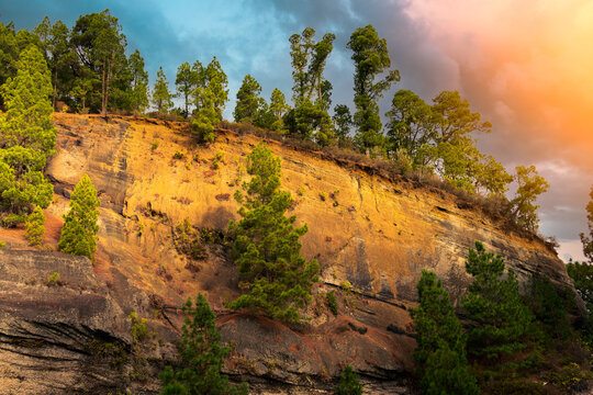 A steep slope of a stone rock in the rays of sunset. Rock formation traces as a visual aid to geology