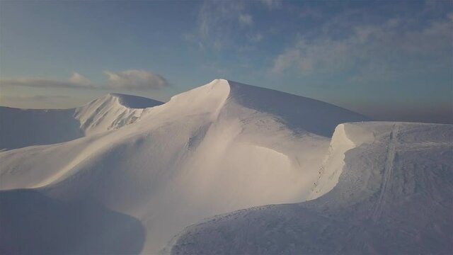 Aerial view of mountain snow-capped peak, at sunrise