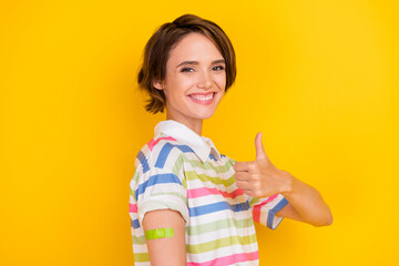 Profile photo of funny young brunette lady with plaster show thumb up wear white t-shirt isolated on yellow color background