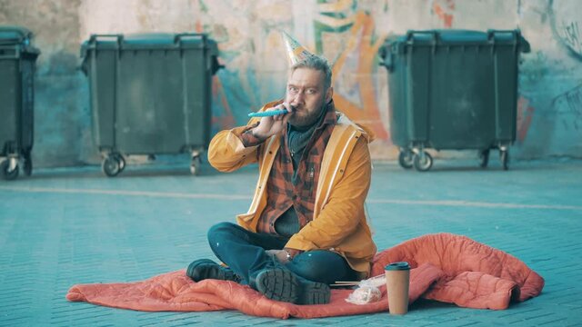 A tramp with a party blower and a birthday hat