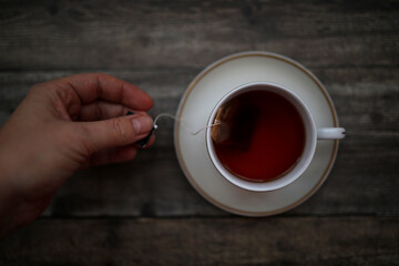 hand holding a tea bag in cup