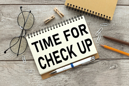 time for check up. text on a notebook that lies on a working wooden table