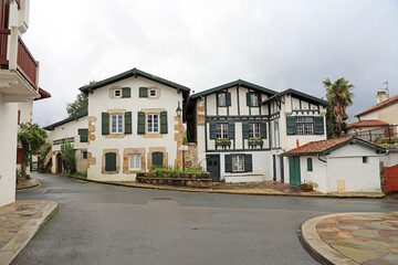 calle de  casas con ventanas verdes en ascain pueblo vasco francés francia 4M0A7776-as21