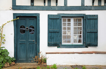 Fototapeta na wymiar fachada de casa con puerta y ventanas verdes en ascain pueblo vasco francés francia 4M0A7787-as21