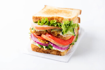 Fresh tasty sandwich with ham, tomato and red onion isolated on a white background.