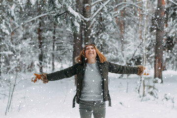 Fototapeta na wymiar Snow in the air on the background of a blurry image of a happy young girl who throws white snow. Christmas holidays, Winter time