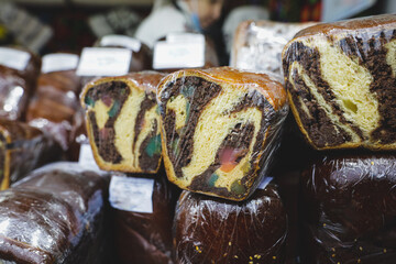 Shallow depth of field (selective focus) image with traditional Romanian winter holidays and easter baked sweet bread dessert named cozonac for sale in an outdoors market in Bucharest, Romania.