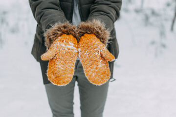 Knitted woolen mittens stained with white snow. winter time, snowball games, christmas holidays
