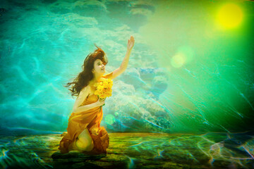 Obraz na płótnie Canvas Girl in a beautiful dress under blue water. Female model posing under water in swimming pool