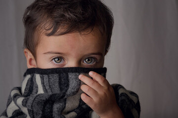 portrait of little boy with a cold with a scarf