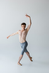 Obraz premium full length of elegant ballet dancer performing ballet dance isolated on grey