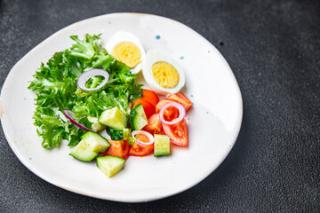 vegetables salad boiled egg cucumber, tomato, onion, lettuce healthy meal food diet snack on the table copy space food background rustic. top view keto or paleo diet