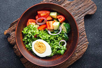 vegetables salad boiled egg cucumber, tomato, onion, lettuce healthy meal food diet snack on the table copy space food background rustic. top view keto or paleo diet
