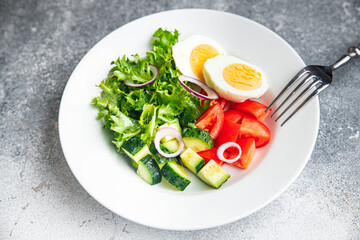 vegetables salad boiled egg cucumber, tomato, onion, lettuce healthy meal food diet snack on the table copy space food background rustic. top view keto or paleo diet