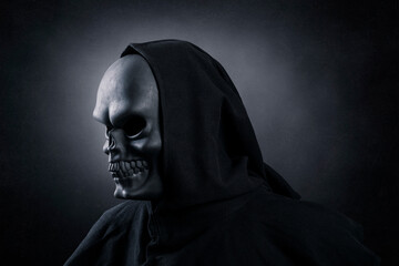 Fototapeta na wymiar Grim reaper over dark misty background