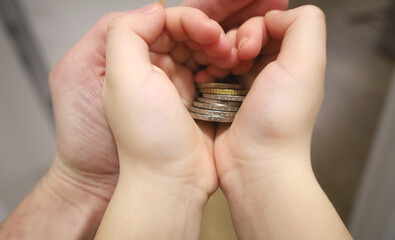 baby hold hands heart with money. The concept of economic and financial literacy. Successful contribution to the future. Closeup of a hand with coins.