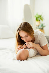 Happy young mother with her newborn baby at home.