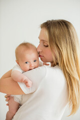 Happy young mother with her newborn baby at home.