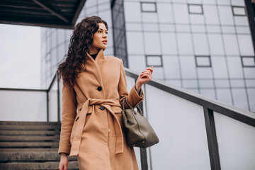 Woman in beige coat walking in the city