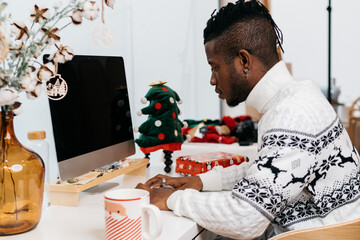 Man wearing a sweater working around Christmas ornaments