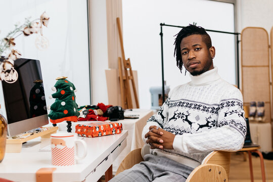 Man sitting in front of a computer around Christmas ornaments