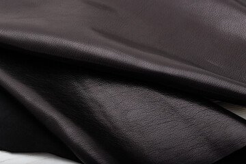 Dark brown chocolate glossy folded natural cow leather on the wooden table
