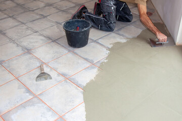 Construction worker leveling compound with putty knife. Renovation, floor leveling screed, mass...
