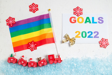 LGBT and New Years goals concept. New Year's steam locomotive with rainbow flag covered with snow.