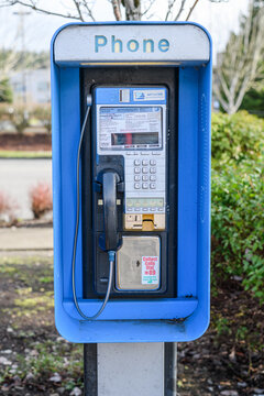 Monroe, WA, USA - December 14, 2021; Stand alone payphone owned by WiMacTel Inc in the urban area of Monroe Washington with word phone 