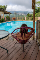 joven mujer tomando un descanso junto a la piscina mientras mira el paisaje